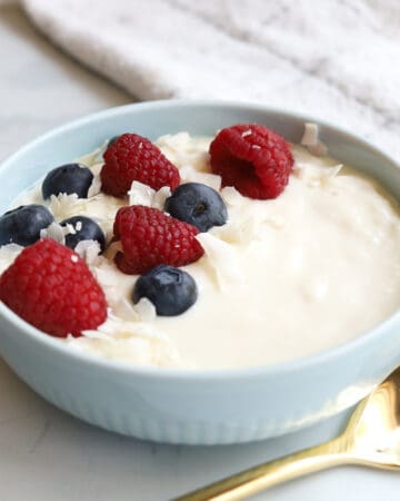 Closeup bowl yogurt with scattered blueberries and raspberries