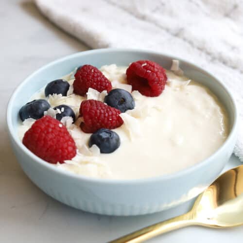 Closeup bowl yogurt with scattered blueberries and raspberries