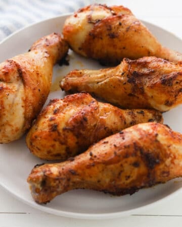Cooked chicken drumsticks on a plate.