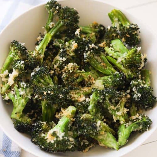Roasted broccoli florets coated with parmesan and panko in a bowl.