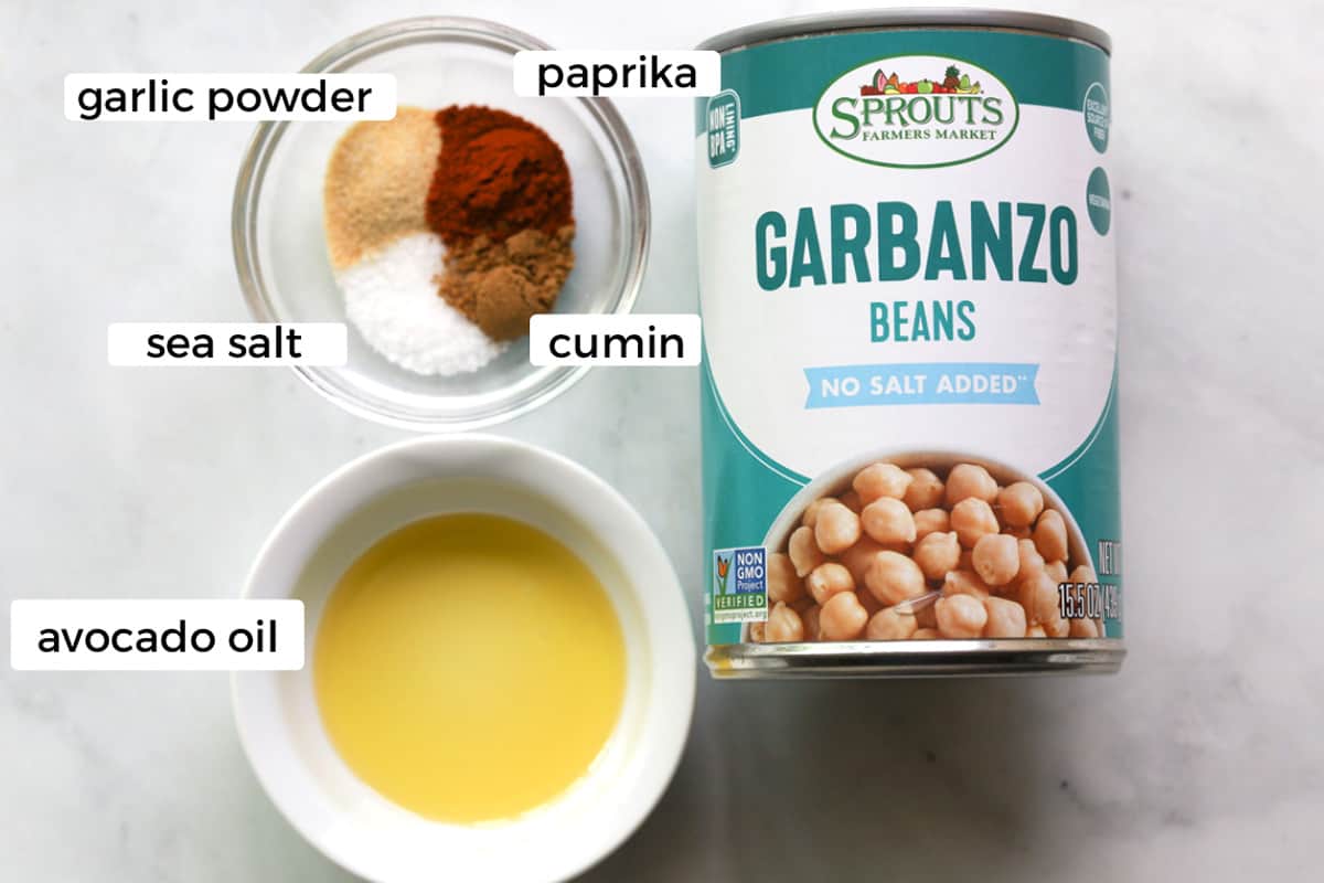 Ingredients on a table, can of garbanzo beans, oil and seasoning in a bowl.