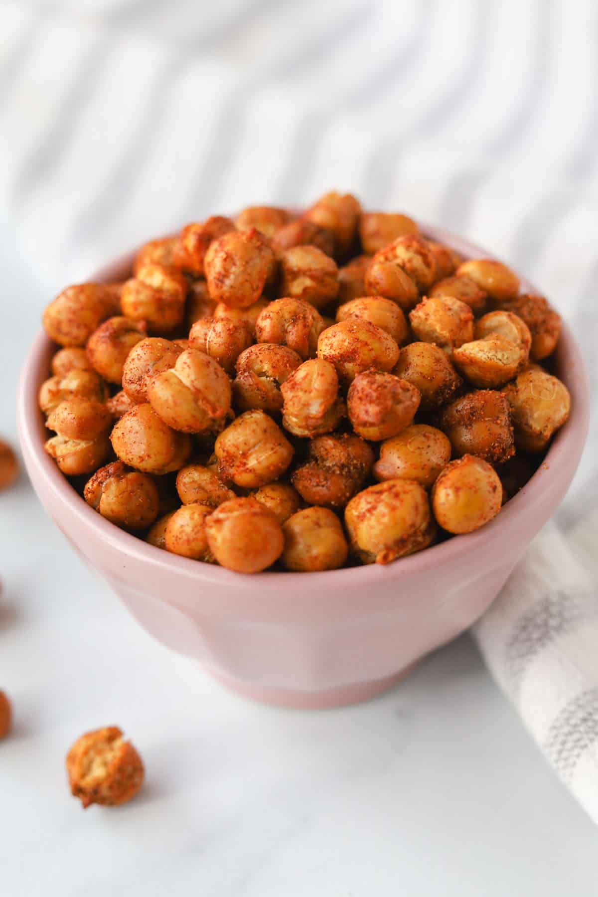 Close up image of roasted chickpeas with seasoning in a bowl.