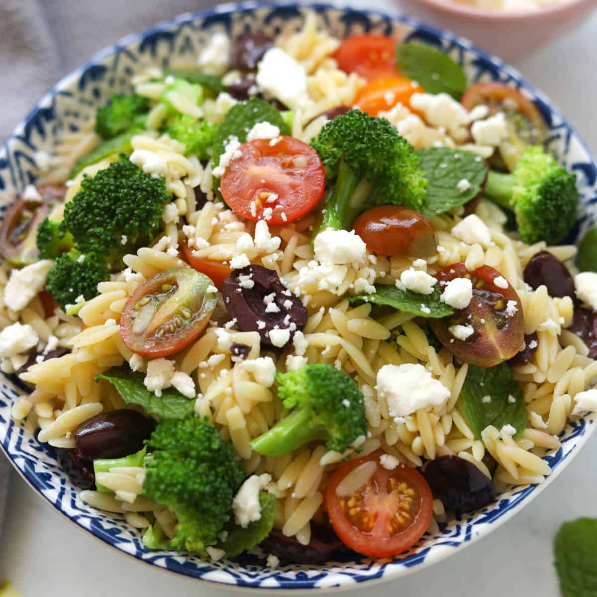Orzo pasta with vegetables in a bowl.
