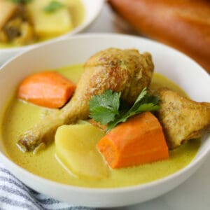Yellow chicken curry with carrots and potatoes in a bowl.