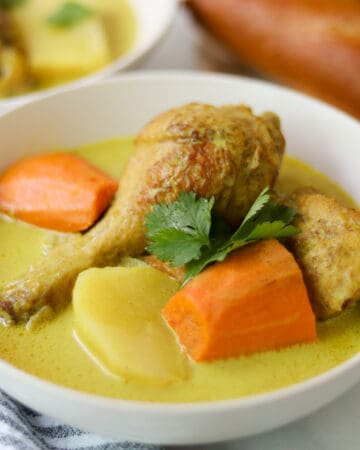 Yellow chicken curry with carrots and potatoes in a bowl.