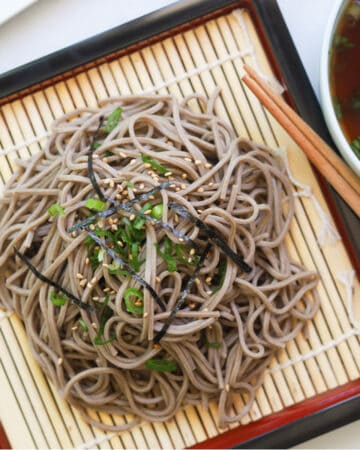 Buckwheat noodles garnished with seaweed strips and sesame seeds
