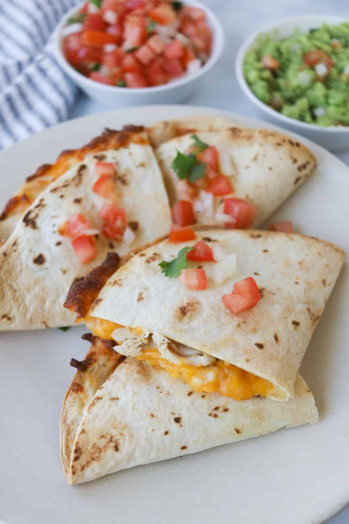 Cut up quesadillas garnished with salsa on a plate.