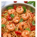 pasta with shrimp and basil in a pan.