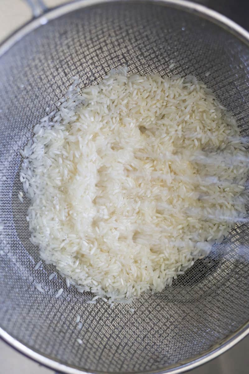 https://apeachyplate.com/wp-content/uploads/2021/10/rinsing-rice-for-turmeric-rice.jpg