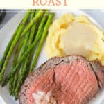 Prime rib with mashed potatoes and asparagus on plate.