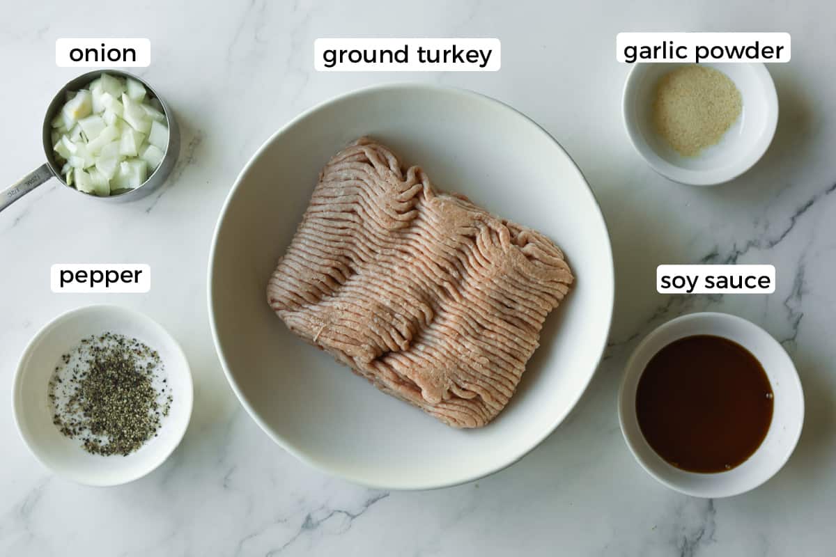 Ground turkey, onion, ground pepper, soy sauce, garlic powder on table.