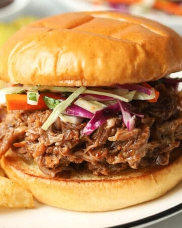 Pulled pork sandwich topped with coleslaw.