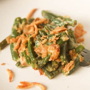 Green bean casserole with fried onions on plate.