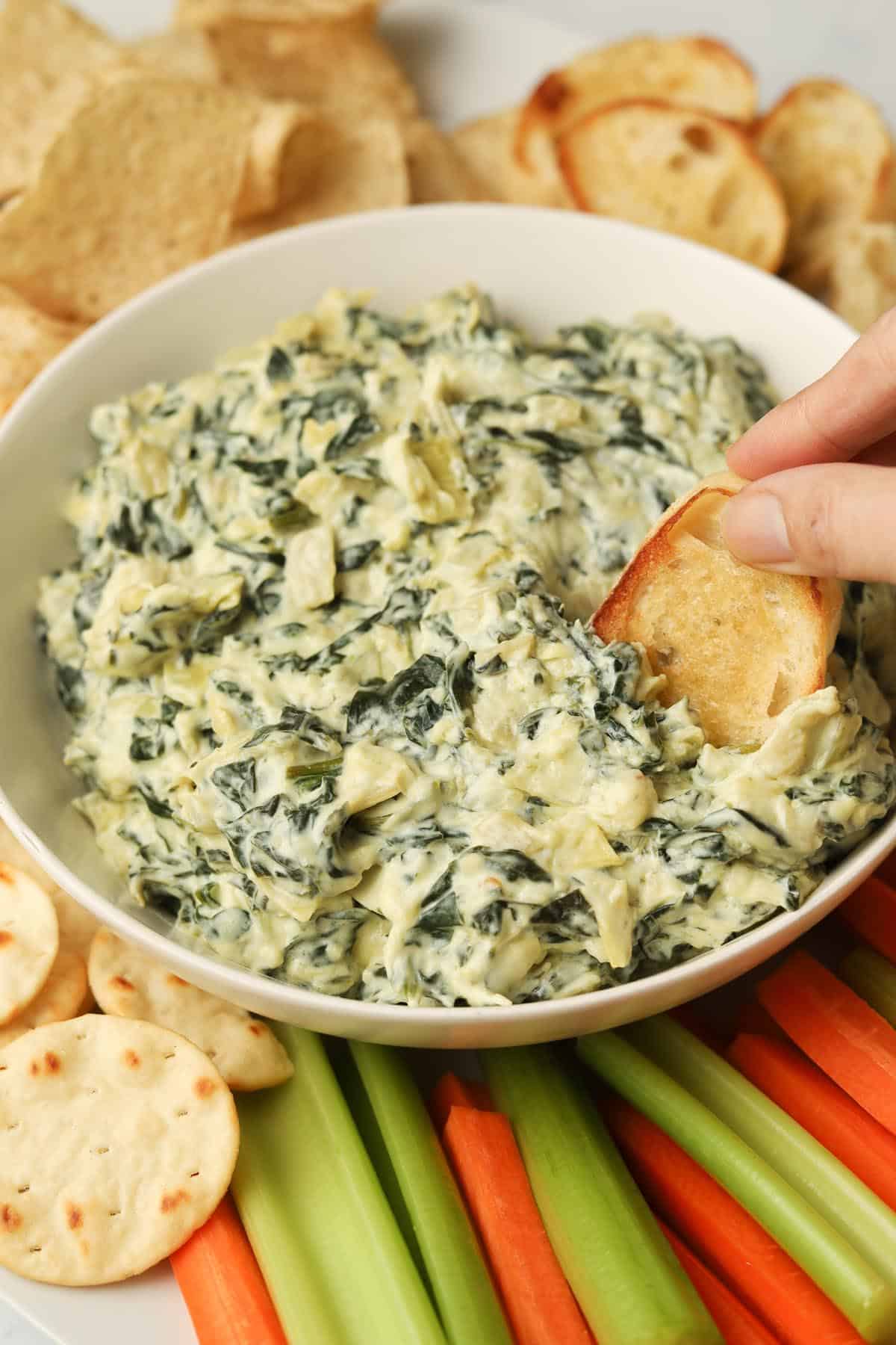Bread dipping in spinach dip.