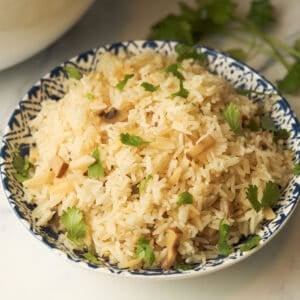 Rice pilaf with almonds and mushrooms in bowl.