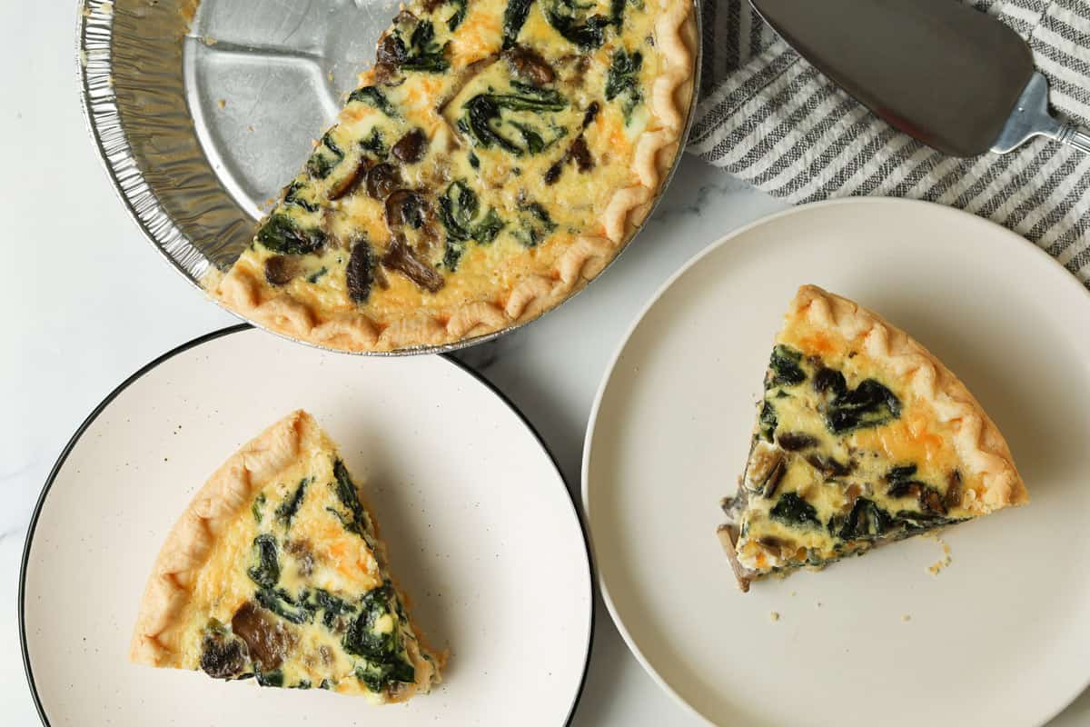 Sliced spinach quiche on plates.