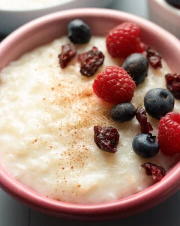 Bowl rice pudding with berries and cinnamon.