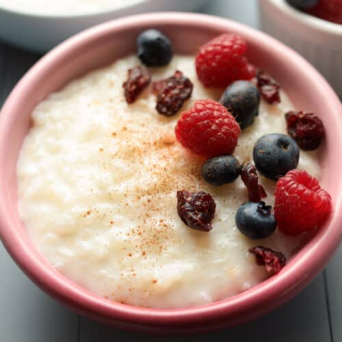 Bowl rice pudding with berries and cinnamon.
