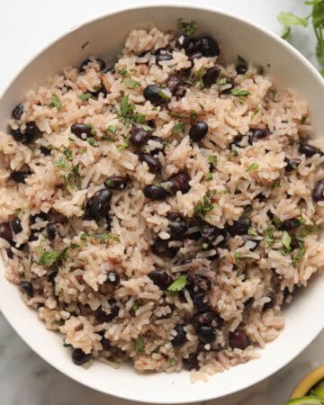 Bowl of rice and black beans garnished with cilantro.