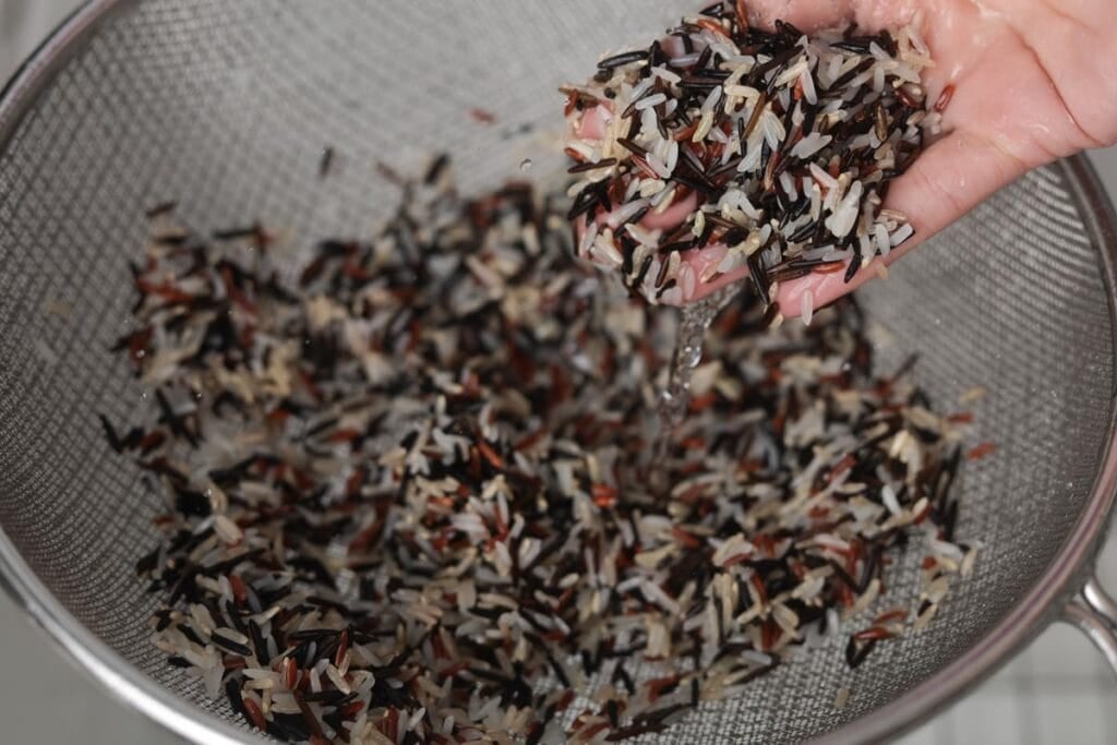 Rinsing wild rice in strainer.