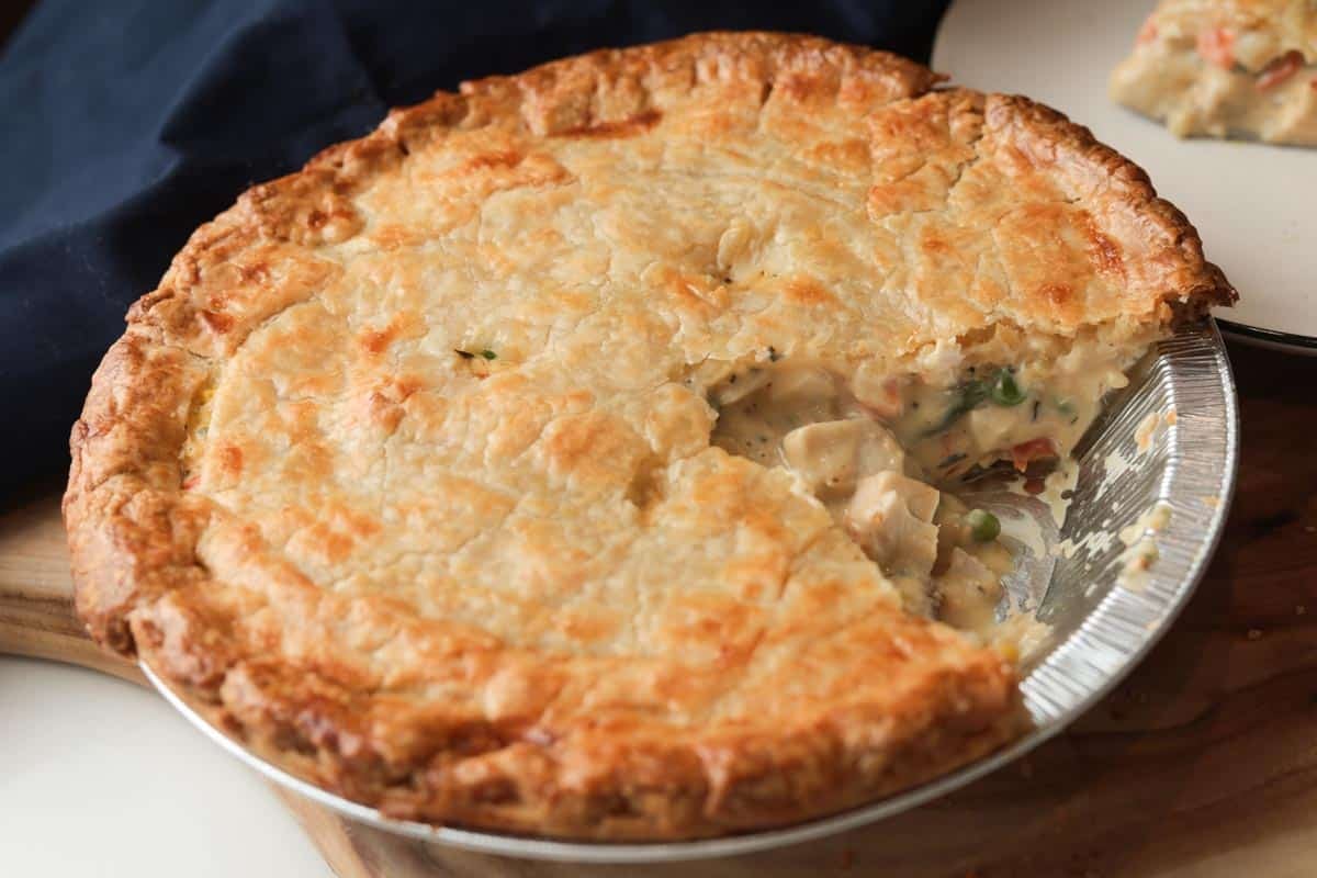 whole chicken pot pie with one slice cut out.