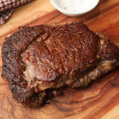 Seared Ribeye steak on a cutting board.