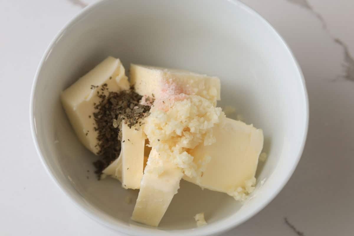 Butter, fresh minced garlic, dried parsley, salt in a bowl.