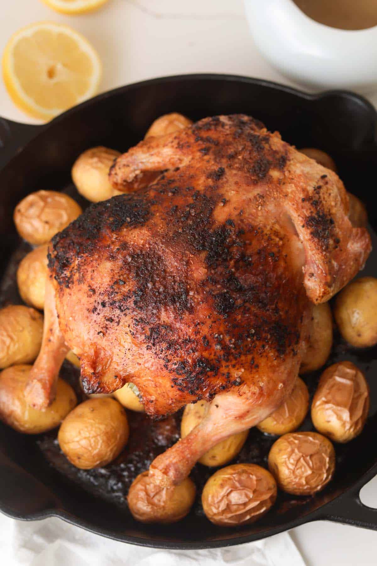 Whole roasted chicken and mini potatoes in cast iron