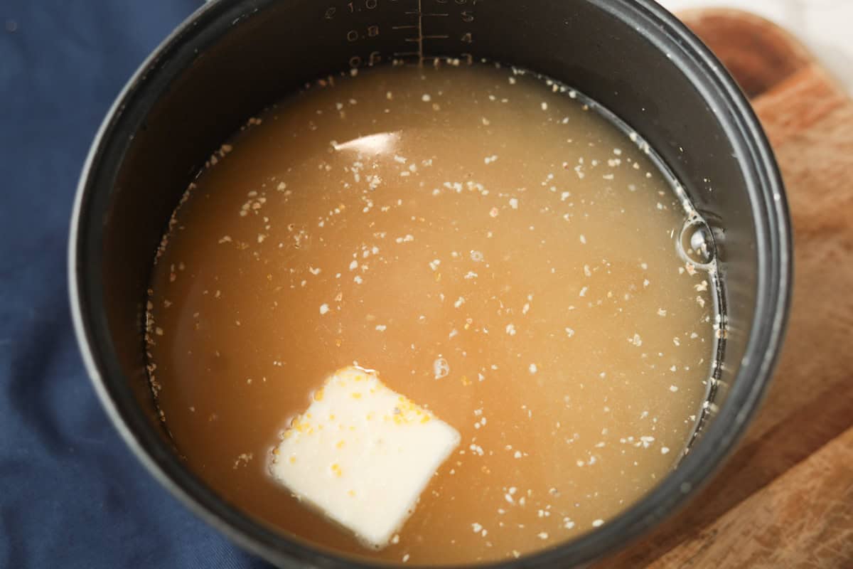 polenta, butter and liquid in rice cooker pot.