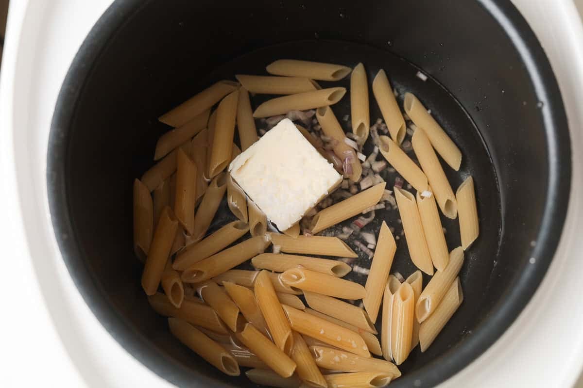 butter, penne pasta, water, shallot in rice cooker pot.
