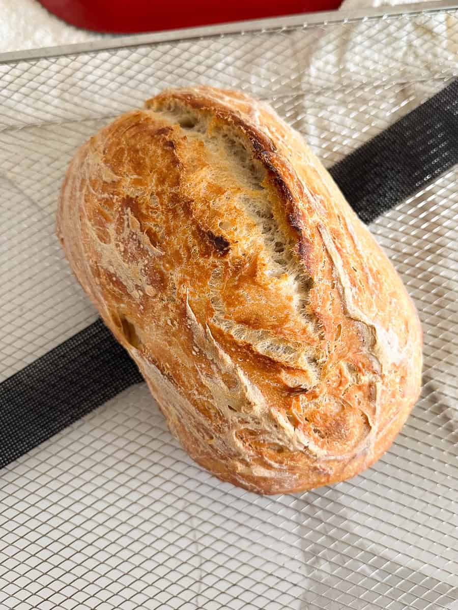 Cooked sourdough bread on cooling rack.