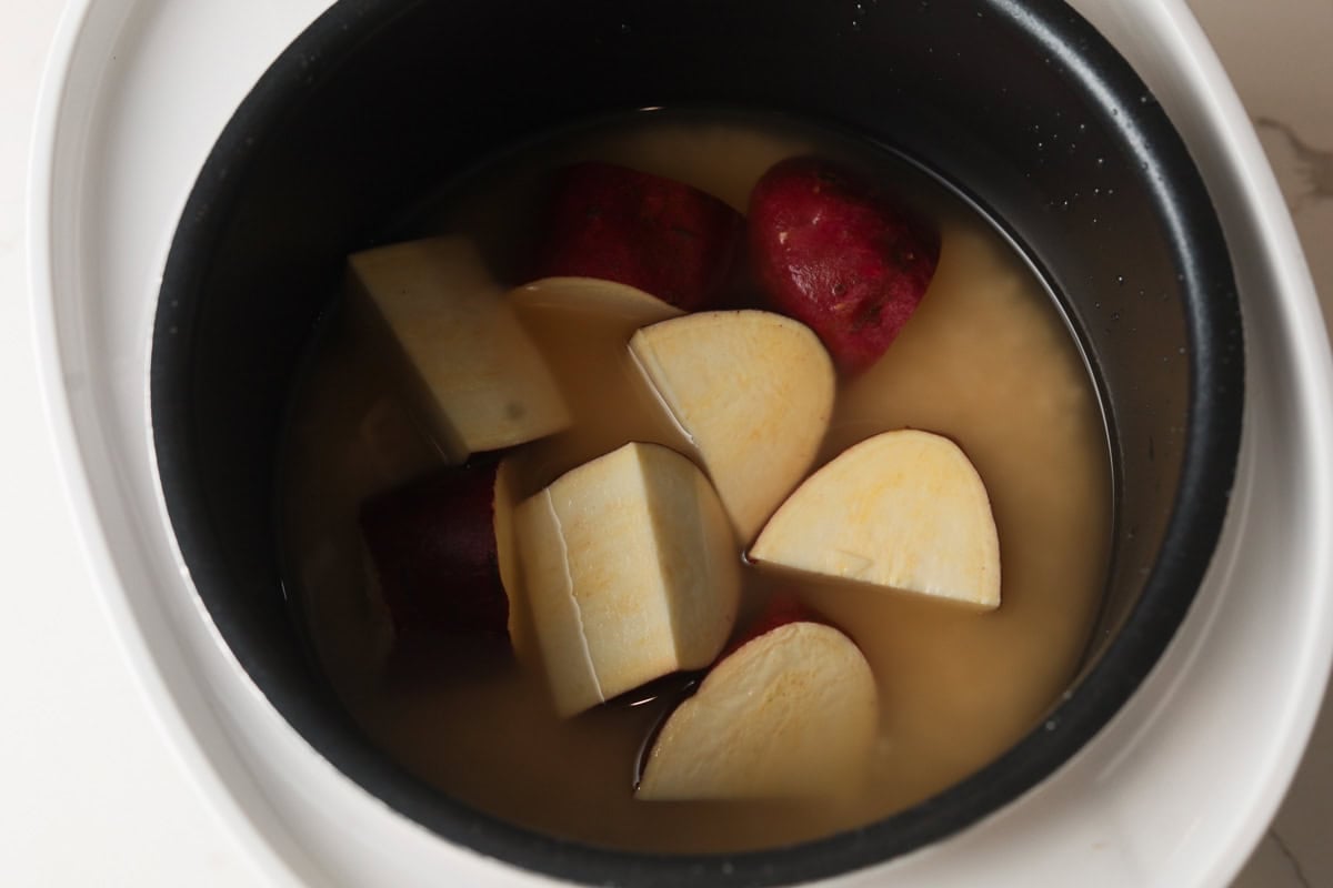 Rice, sweet potato and water in pot.
