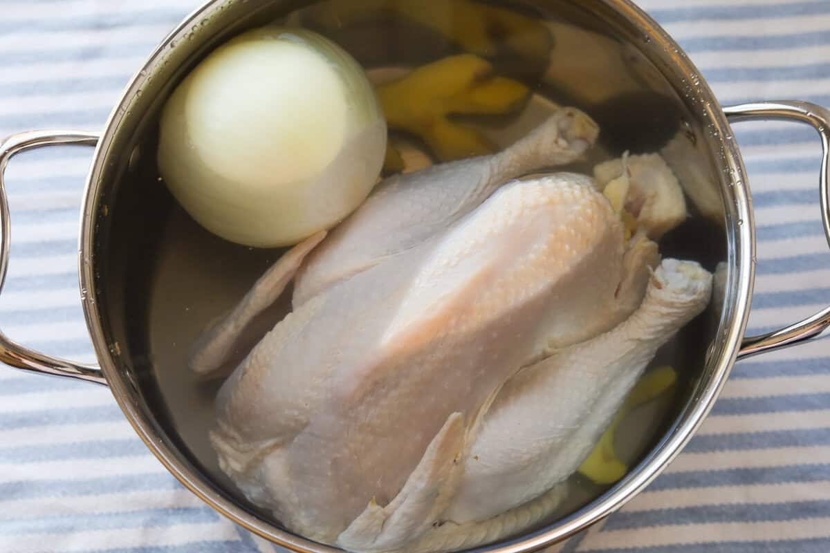 chicken, onion, ginger in a pot of water.