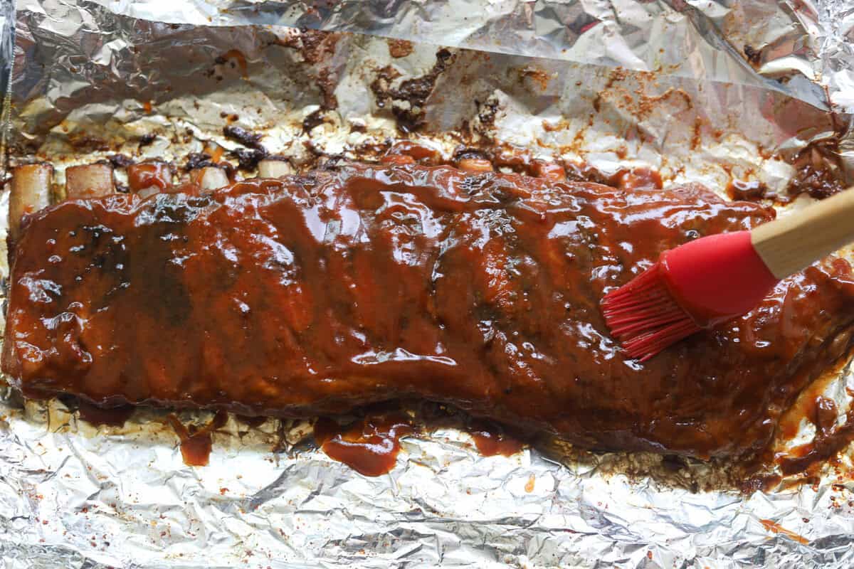 BBQ sauce on a rack of st louis ribs.