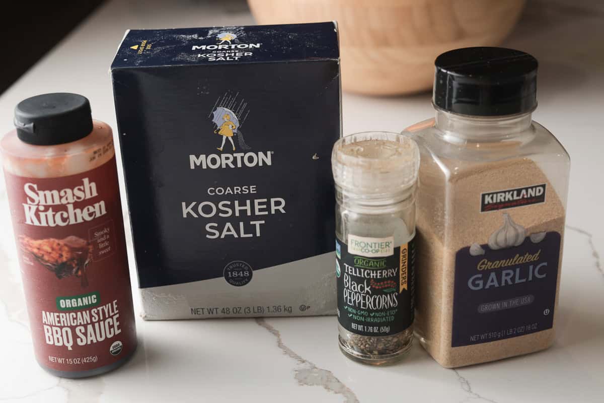 Ingredients on table; bbq sauce, kosher salt, pepper, garlic powder.
